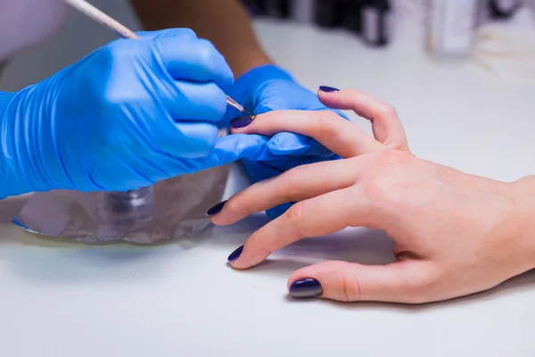 Manicura tratando cliente en el salón de belleza - pintura en el nai —  Fotos de Stock