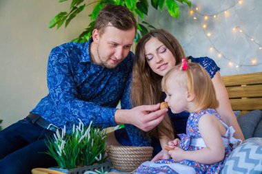 Mutlu genç ebeveynler ve küçük kızları birlikte oynuyorlar.