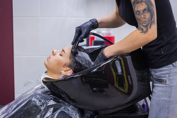 Cabeleireiro lavar o cabelo da mulher cliente — Fotografia de Stock
