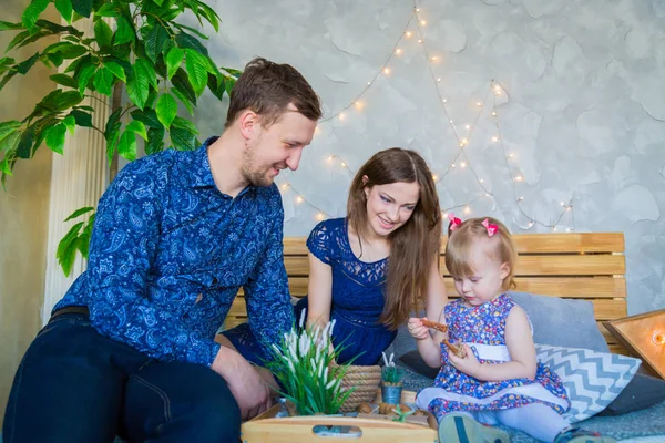 Mutlu genç ebeveynler ve küçük kızları birlikte oynuyorlar.