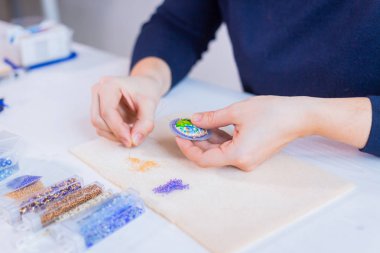 Tasarımcı el yapımı broş yapıyor