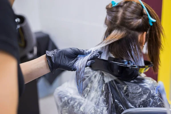 Cabeleireiro profissional colorir o cabelo da mulher cliente no estúdio — Fotografia de Stock