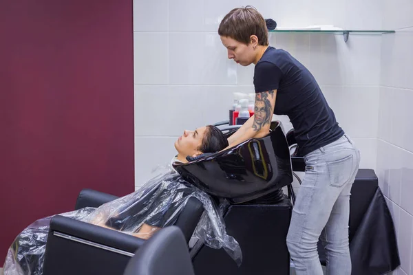 Peluquería lavar el cabello de la mujer cliente —  Fotos de Stock