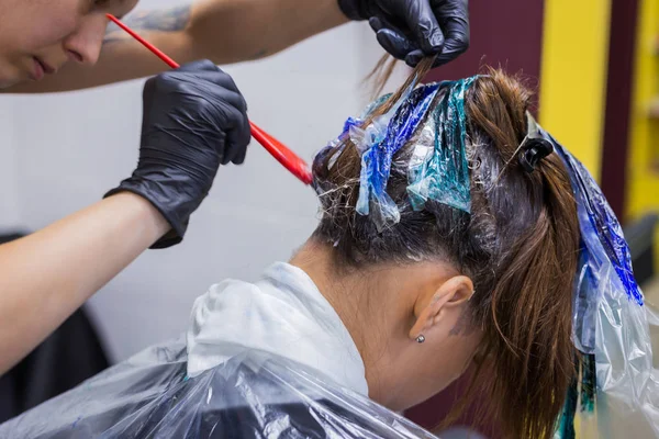 Cabeleireiro profissional colorir o cabelo da mulher cliente no estúdio — Fotografia de Stock