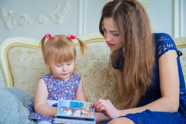 Genç anne ve küçük kızı fotobook 'a benziyorlar.