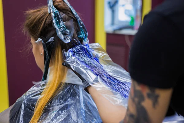 Coiffeur professionnel coloriant les cheveux de la cliente au studio — Photo