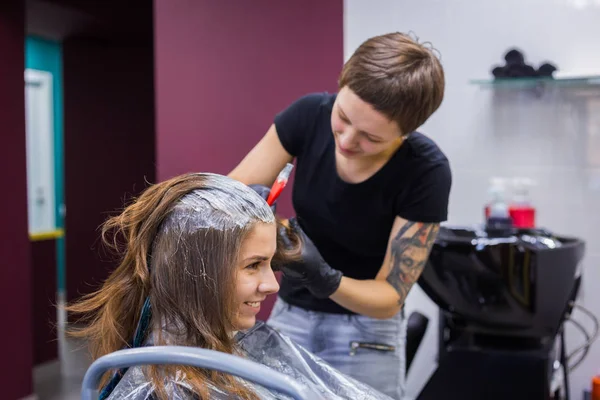 Cabeleireiro profissional colorir o cabelo da mulher cliente no estúdio — Fotografia de Stock