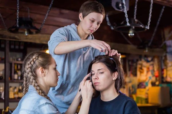 Визажист и парикмахер, работающий с клиенткой — стоковое фото