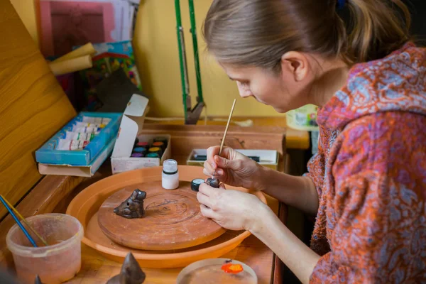Professional woman potter painting ceramic souvenir penny whistle in pottery — Stock Photo, Image