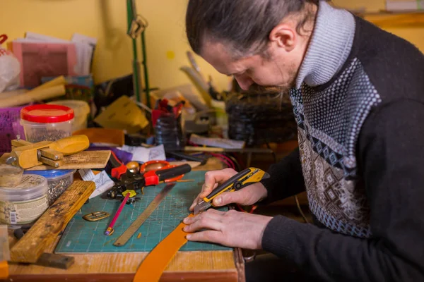 Skinner working with leather belt