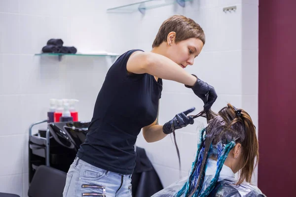 Cabeleireiro profissional colorir o cabelo da mulher cliente no estúdio — Fotografia de Stock