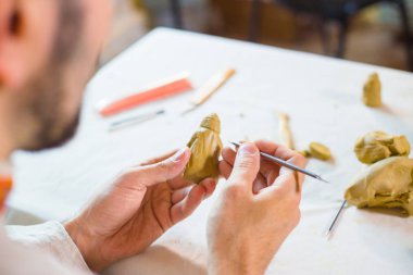 Potter, masa oyunu için kil figürü yapıyor