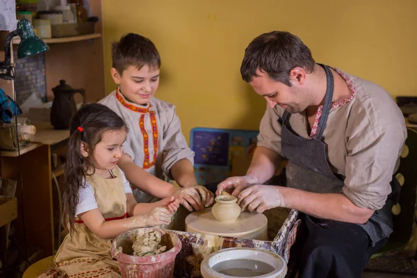 Potter çömlek atölyesinde seramik ile nasıl çalışılacağını gösteriyor.