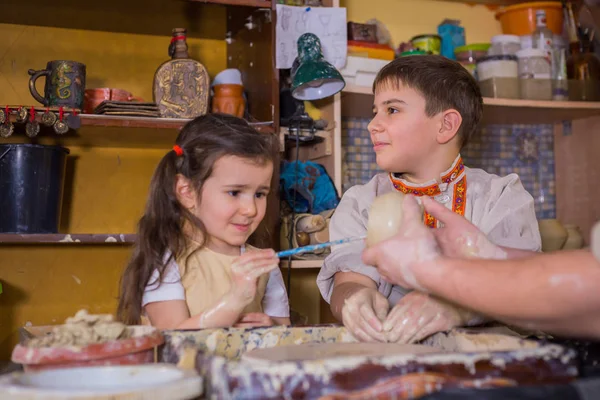 Potter showing how to work with ceramic in pottery studio