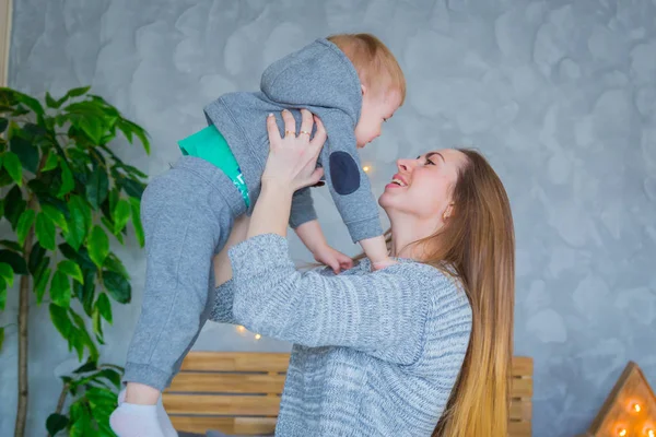 Young mother throwing up her baby son — Stock Photo, Image