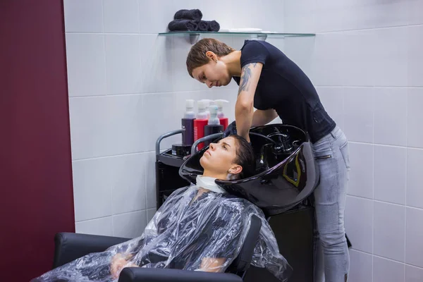 Cabeleireiro lavar o cabelo da mulher cliente — Fotografia de Stock