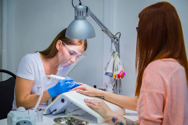 Kvinde Neglesalon Modtager Manicure Kosmetolog Med Elektrisk Neglefil Kvinden Får - Stock-foto