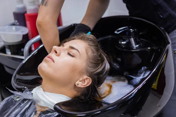 Friseur wäscht Haare einer Kundin — Stockfoto