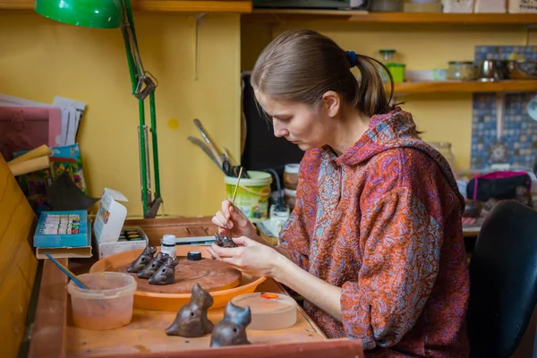 Professional woman potter painting ceramic souvenir penny whistle in pottery — Stock Photo, Image