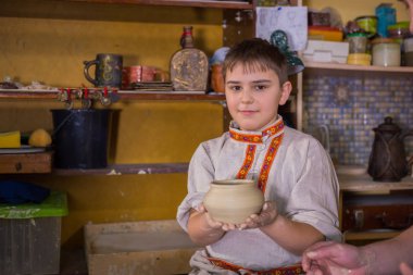 Potter çömlek atölyesinde seramik ile nasıl çalışılacağını gösteriyor.