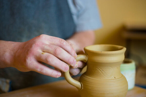 Professional male potter working in workshop, studio