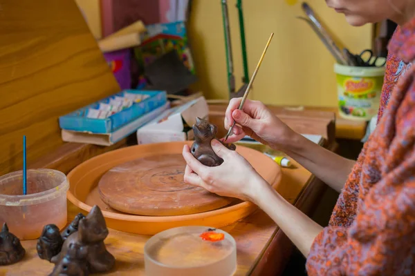 Professional woman potter painting ceramic souvenir penny whistle in pottery — Stock Photo, Image