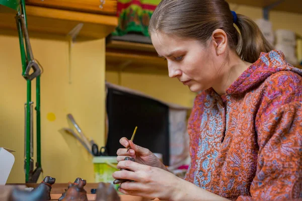 Mujer profesional alfarero pintura cerámica recuerdo penique silbato en cerámica — Foto de Stock