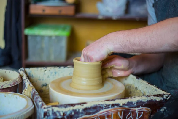 Pembuat tembikar profesional laki-laki bekerja dengan tanah liat pada roda tembikar Stok Foto