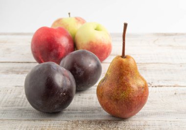 Elma armut bir erik ile natürmort. Ahşap bir gemide gönderilmiş