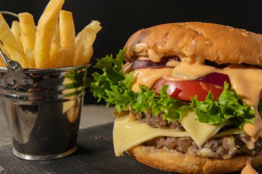 Burger patates kova ile. koyu ahşap arka plan üzerinde hizmet veren