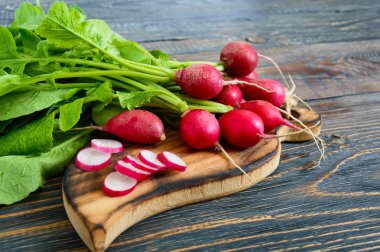 Yaz hasat kırmızı turp. Büyüyen organik sebze. Büyük ham taze sulu Bahçe turp yemeye hazır karanlık kurullarında demet.