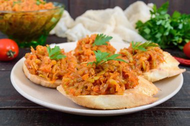 Kabak Koyu ahşap bir masa üzerinde bir gevrek baget üzerinde havyar. Sandviç haşlanmış sebzeler. Vejetaryen meze.