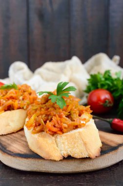 Kabak Koyu ahşap bir masa üzerinde bir gevrek baget üzerinde havyar. Sandviç haşlanmış sebzeler. Vejetaryen meze.