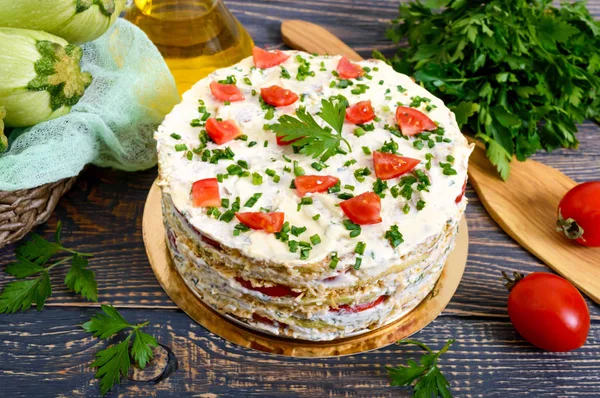 A delicious cake of zucchini, tomatoes and cheese on a wooden table. Vegetable cake.