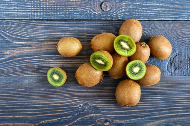 Taze olgun kivi ahşap bir masa üzerinde. Bütün ve yarım kesilmiş meyve. Tropikal meyve. Sağlıklı gıda. Üstten görünüm.