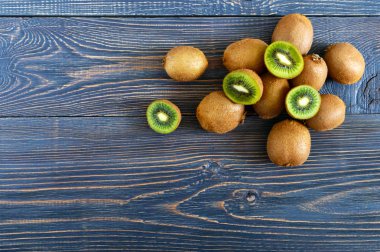 Taze olgun kivi ahşap bir masa üzerinde. Bütün ve yarım kesilmiş meyve. Tropikal meyve. Sağlıklı gıda. Üstten görünüm.