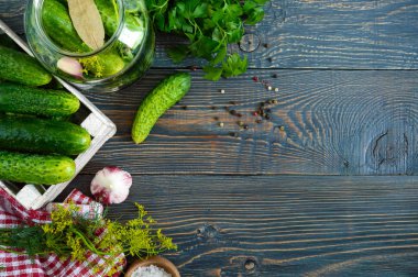 Turşu. Bir kavanoz, bir ahşap kutu, baharatlar, otlar bir tablo taze hasat lezzetli salatalık turşusu. Salatalık turşu için hazırlanması. Üstten görünüm.