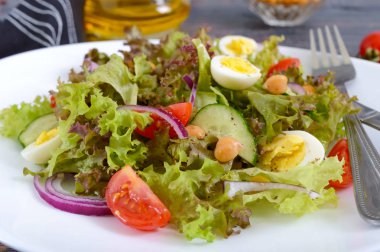 Taze sebze, yeşillik, bıldırcın yumurtası ve nohut ile hafif yaz salatası. Vejetaryen yemek. Doğru beslenme. Yakın çekim.