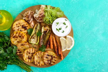 Izgara sebze, taze otlar, sos bir ahşap tepsi üzerinde. Sağlıklı gıda. Lezzetli bir meze. Üstten görünüm.