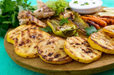 Izgara sebze, taze otlar, sos bir ahşap tepsi üzerinde. Sağlıklı gıda. Lezzetli bir meze.