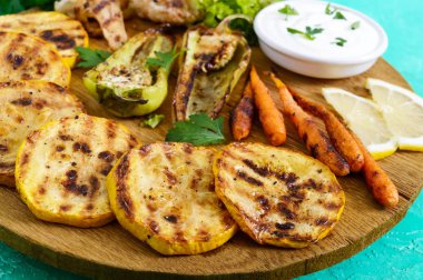 Izgara sebze, taze otlar, sos bir ahşap tepsi üzerinde. Sağlıklı gıda. Lezzetli bir meze.