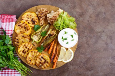 Izgara sebze, taze otlar, sos bir ahşap tepsi üzerinde. Sağlıklı gıda. Lezzetli bir meze. Üstten görünüm.