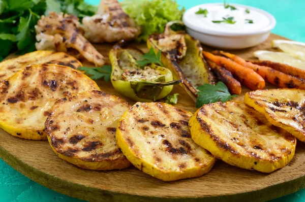 Izgara sebze, taze otlar, sos bir ahşap tepsi üzerinde. Sağlıklı gıda. Lezzetli bir meze.