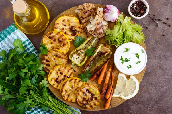 Izgara sebze, taze otlar, sos bir ahşap tepsi üzerinde. Sağlıklı gıda. Lezzetli bir meze. Üstten görünüm.