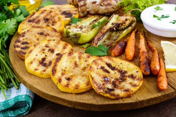 Izgara sebze, taze otlar, sos bir ahşap tepsi üzerinde. Sağlıklı gıda. Lezzetli bir meze.