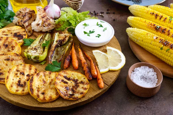 Izgara sebze, taze otlar, sos bir ahşap tepsi üzerinde. Sağlıklı gıda. Lezzetli bir meze.