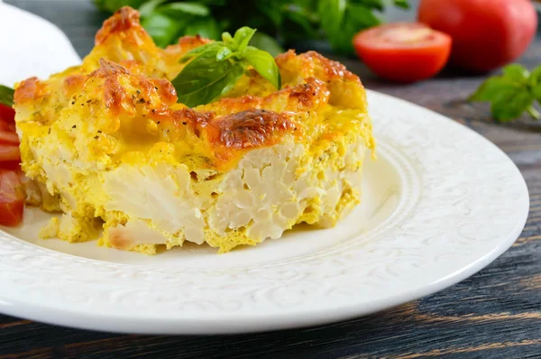 Karnabahar koyu ahşap arka plan üzerinde bir tabakta gelen lezzetli yararlı güveç. Vejetaryen menü. Doğru beslenme.