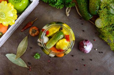 Bir cam kavanoza Marine sebze. Çeşitli salatalık, biber, havuç, patissons, kabak. Turşu.