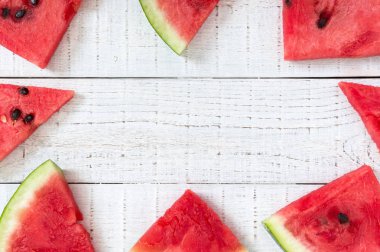 Karpuz Beyaz ahşap zemin üzerinde sulu dilim. Berry gıda arka plan. Üstten görünüm. Düz yatıyordu. Projeniz için boş alan.