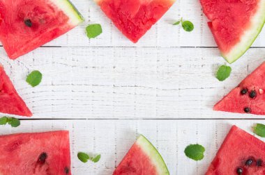 Karpuz Beyaz ahşap zemin üzerinde sulu dilim. Berry gıda arka plan. Üstten görünüm. Düz yatıyordu. Projeniz için boş alan.